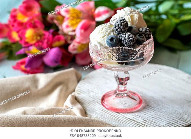 Vanilla ice cream with fozen berries in the glass vase