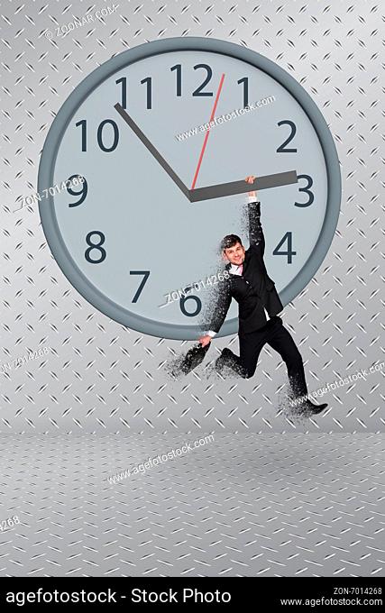 Man hang on clock on grey background