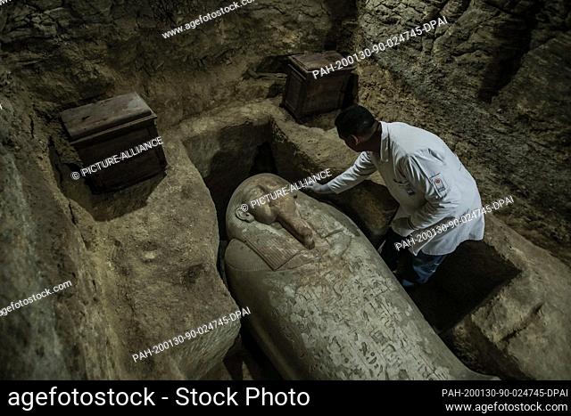 30 January 2020, Egypt, Minya: An archaeologist works inside a communal tomb, one of three newly discovered tombs of the high priests of ancient Egyptian deity...