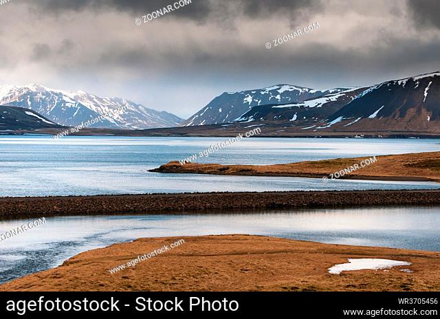 Icelandic dramatic landscape with frozen lake and mountains covered in snow at snaefellsnes peninsula in Iceland in wintertime