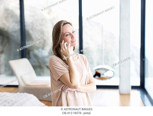 Woman talking on cell phone in modern living room