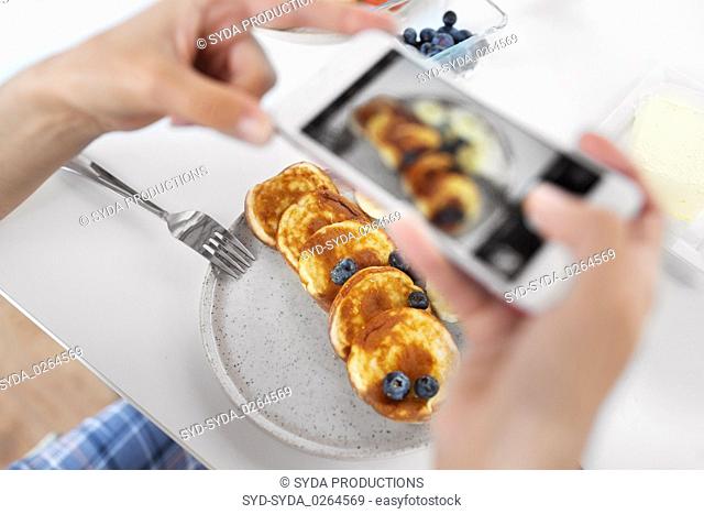hands with smartphones photographing food