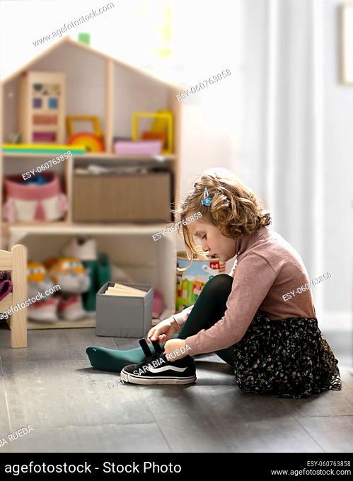Little girl playing in her room and attentive to her chores