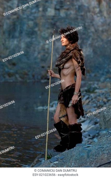 cavewoman fishing near a lake