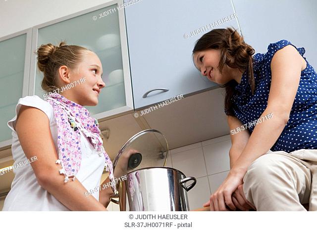 Smiling girls cooking in kitchen