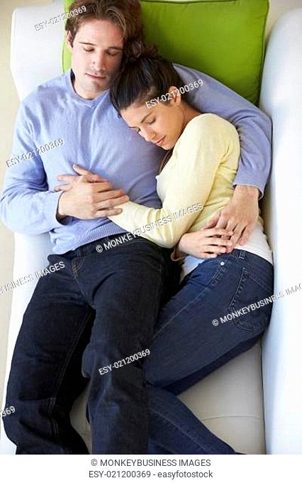Overhead View Of Couple Relaxing On Sofa