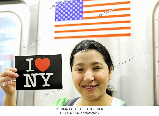 Hispanic, Asian, woman holding 'I Love New York' postcard, Subway train metro station, New York City