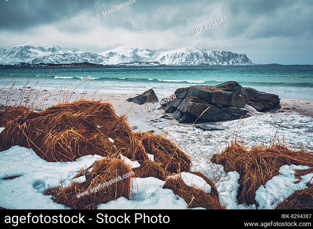 Waves of Norwegian sea on rocky beach of fjord. Ramberg beach, Lofoten islands, Norway, Europe