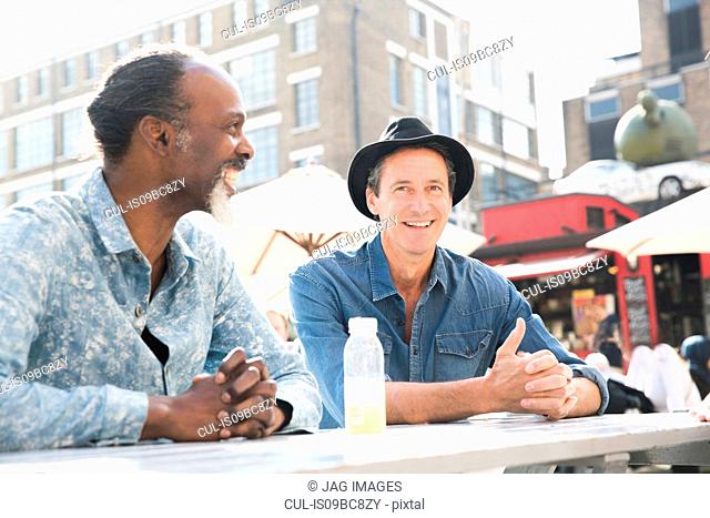 Friends chatting at food market, London, UK