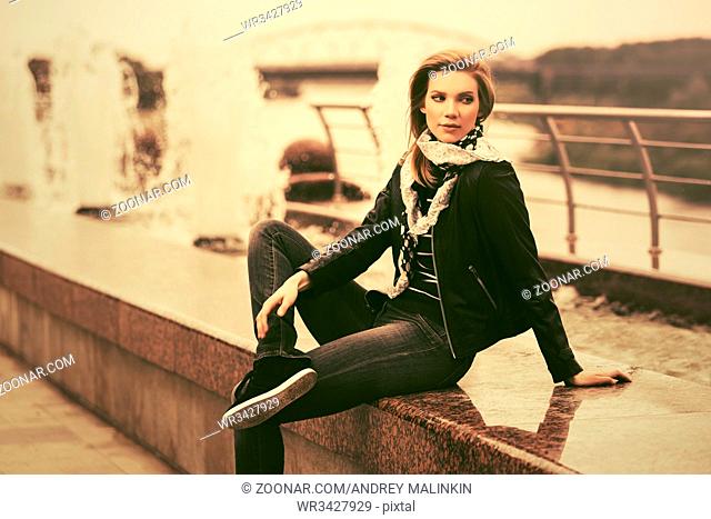 Happy young fashion woman in leather jacket outdoor