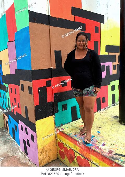 Marieluce Matría Souza stands in front of painted house fronts in the Favela Complexo do Alemão, a big favela in Rio de Janeiro, Brazil, 28 April 2016