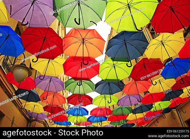 Colored umbrellas hanging at top. Set of different umbrellas. Local landmark. Cafe decoration in Lodz. Multicolored umbrella. Street decoration