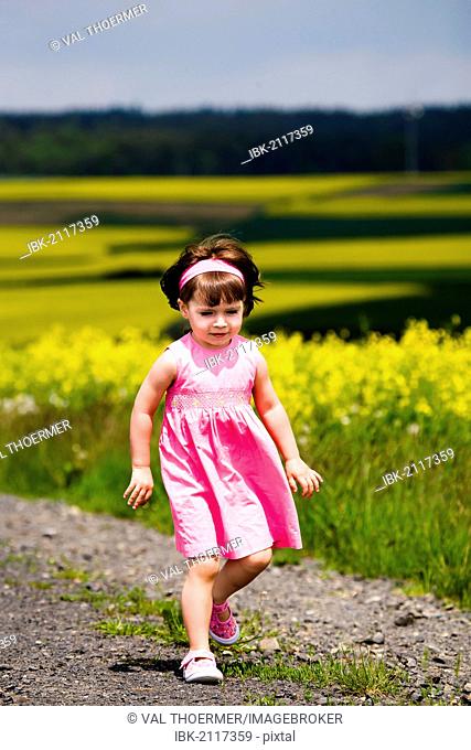 Little girl walking on field path