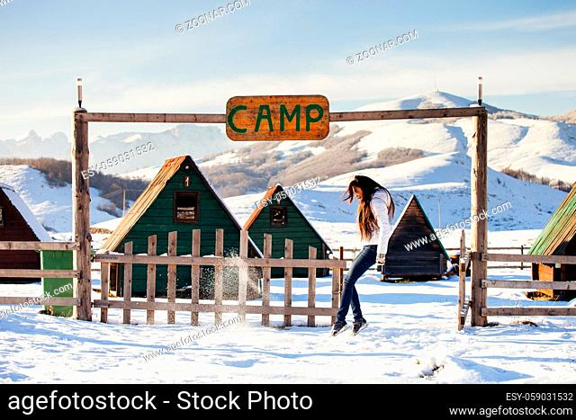 woman play with snow at ski resort camp with happy face. Winter snowy mountains background