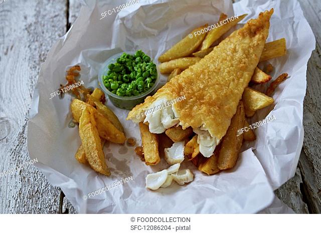 Fish and chips with mushy peas on paper