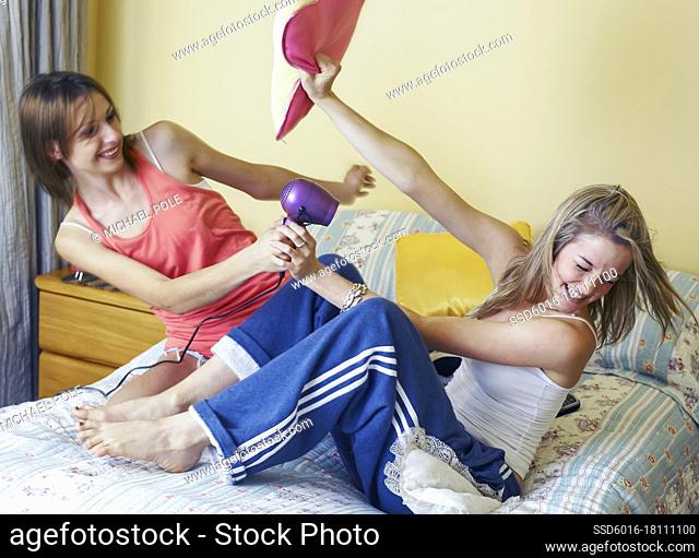 Two female students play fighting in students bedroom