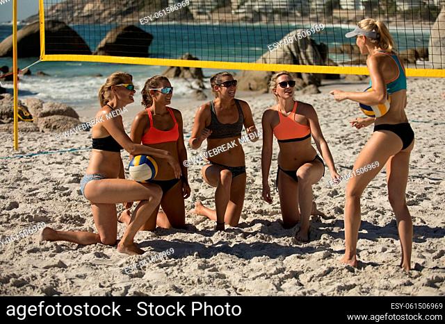 Female volleyball players discussing on the beach