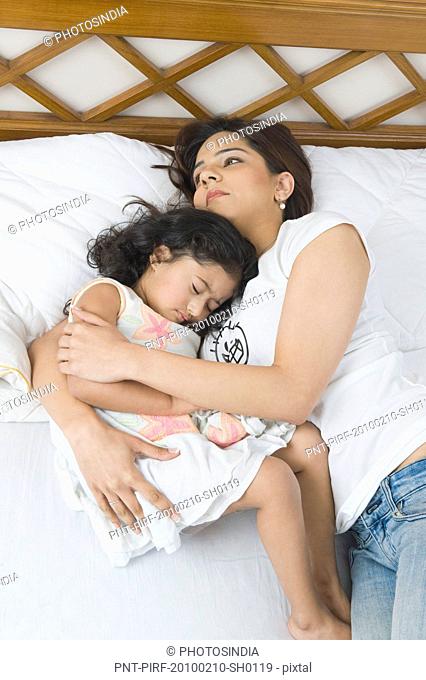 Woman resting on the bed with her daughter