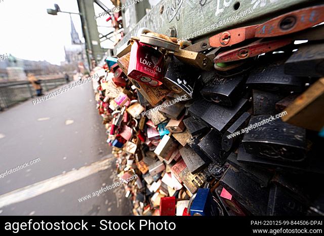 25 January 2022, North Rhine-Westphalia, Cologne: Numerous locks are attached to the Hohenzollern Bridge. Lovers immortalize their names and feelings here on...