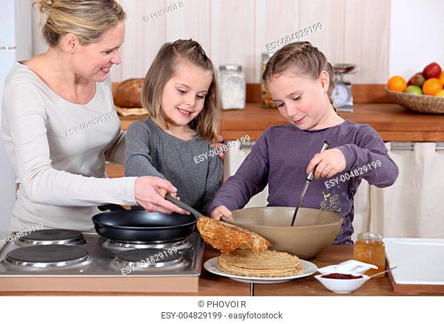 Mother and daughters making pancakes