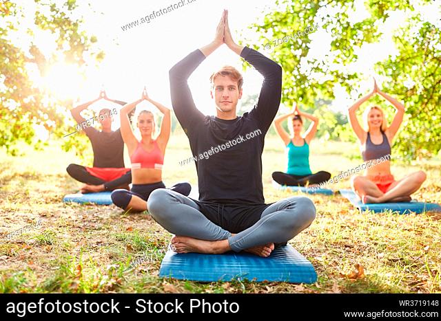 Gruppe Freunde bei einer Yoga Meditation für Balance und innere Ruhe in der Natur