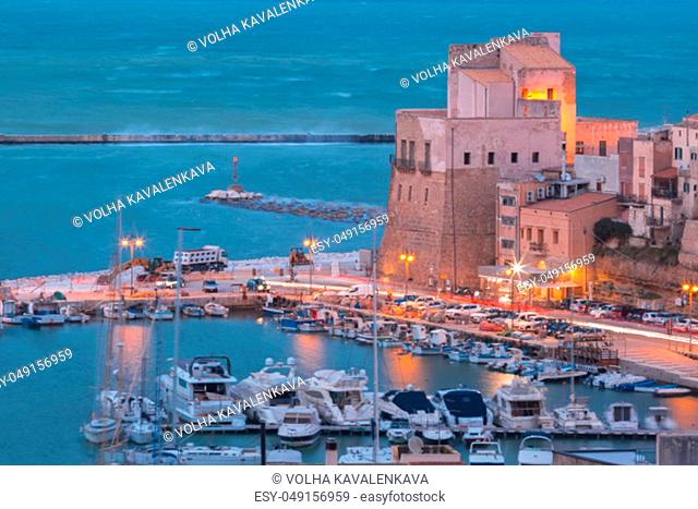 Medieval fortress in Cala Marina, harbor in coastal city Castellammare del Golfo at sunset, Sicily, Italy