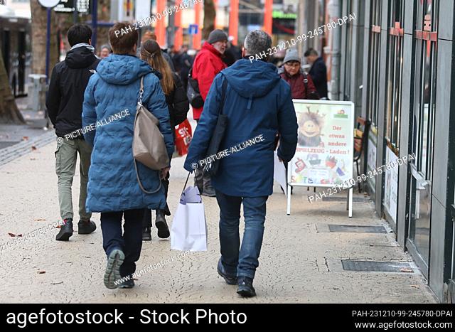 10 December 2023, Thuringia, Jena: Passers-by with shopping bags walk through the city center. Numerous people take advantage of the shopping opportunity on the...