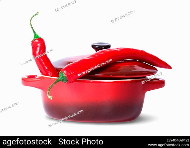 Two red chili peppers in saucepan with lid isolated on white background