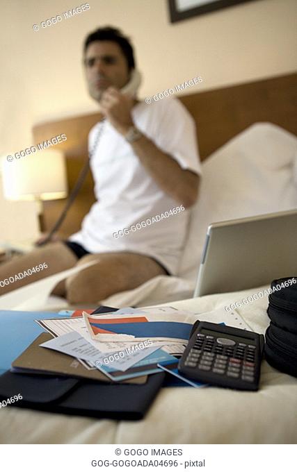 Businessman's travel papers on hotel bed