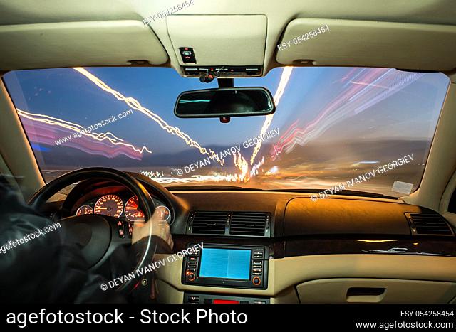 Car interior on driving. Blurred night lights