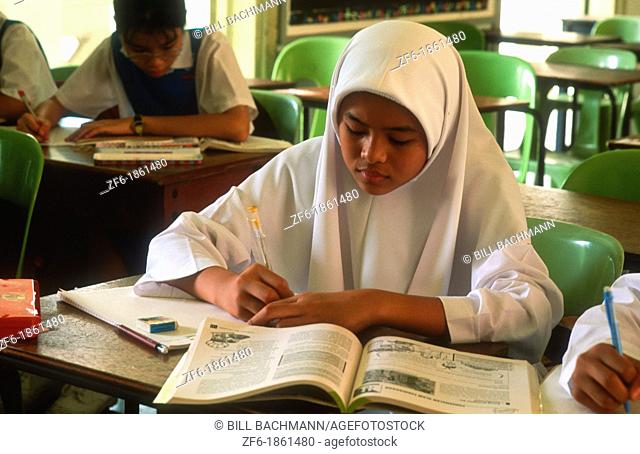 Malaysia, Kuala Lumpur, Muslim school children writing in classroom