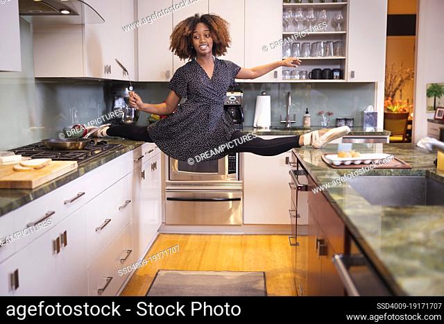 Female ballet dancer cooking in a residential kitchen