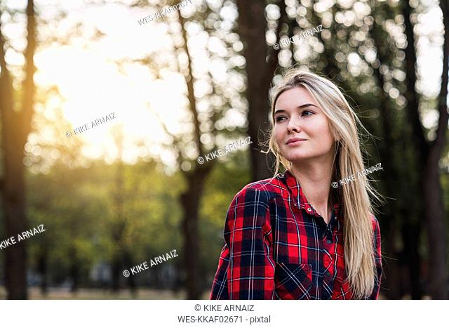 Portrait of young woman wearing plaid shirt in nature