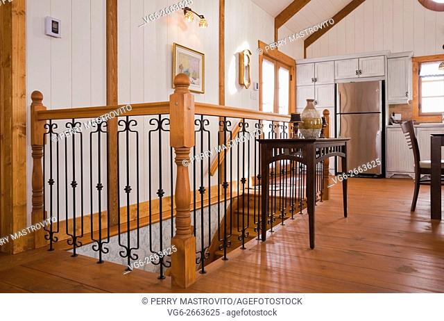 Railing surrounding the staircase inside the extension of a Canadiana cottage style fieldstone residential home built to look old in 2002, Quebec, Canada