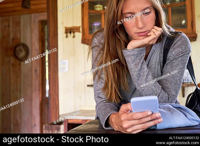 young woman using smartphone in home