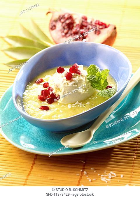 Pineapple soup with coconut ice cream and pomegranate seeds
