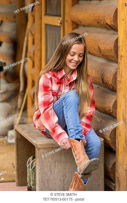 Girl putting on cowboy boots