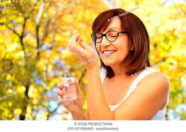 senior woman smelling perfume from her wrist
