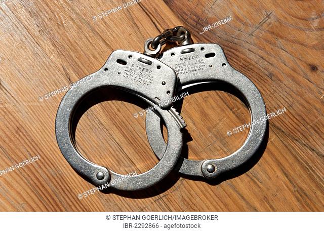 Smith and Wesson handcuffs lying on a wooden table