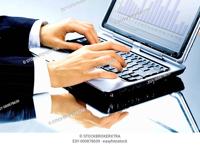 Image of human hand typing a business document on the laptop