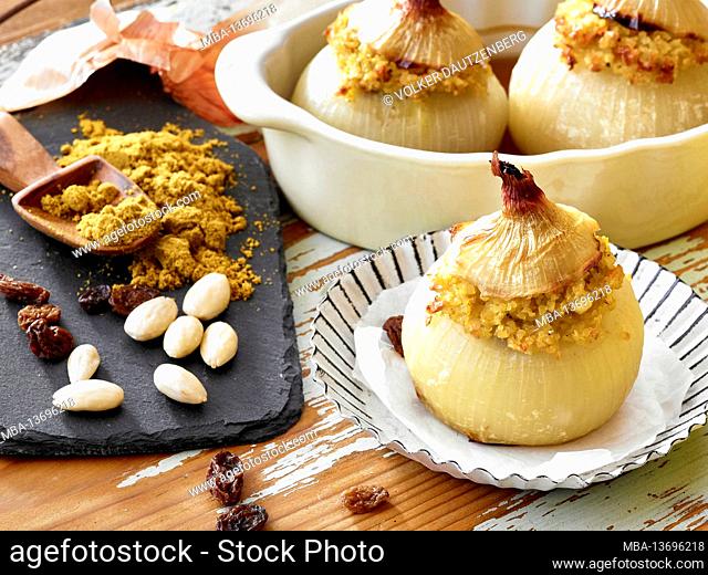 Filled onion with bulgur, North African style, the finished dish, serial motif, two onions in an oven dish and one onion in the foreground in a pan next to a...