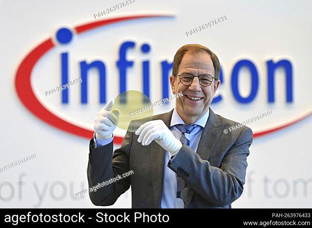 Dr. Reinhard Ploss Chairman of Management (CEO) in front of the logo, holding a transparent wafer (semiconductor), emblem, lettering, single image