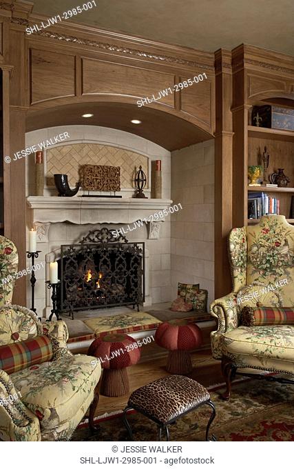 LIVING ROOMS, two yellow wing chairs, leopard print footstool and two mushroom shaped footstools, alcove fireplace, paneled wood walls, built in bookshelves