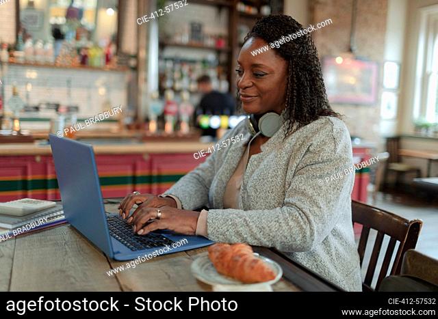 Woman working at laptop in cafe