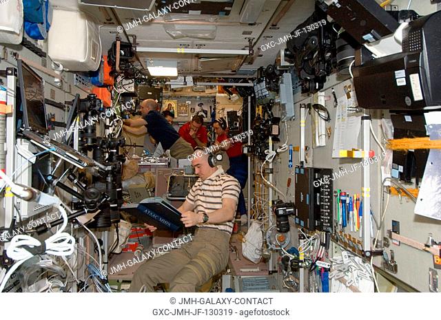 Expedition 30 crew members are pictured in the Zvezda Service Module of the International Space Station as they prepare to move to the appropriate Soyuz...
