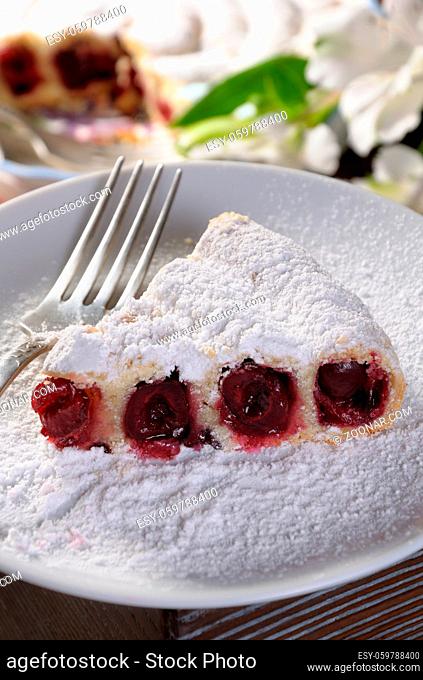 a piece of cherry pie sprinkled with powder sugar on a plate