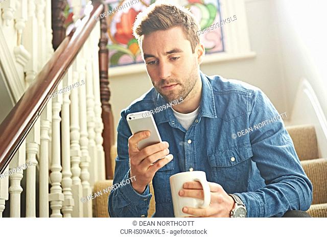 Man using smartphone on stairs