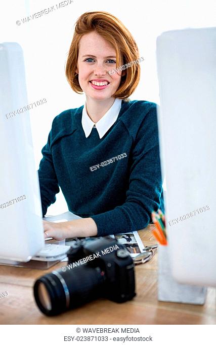smiling hipster photographer on her computer
