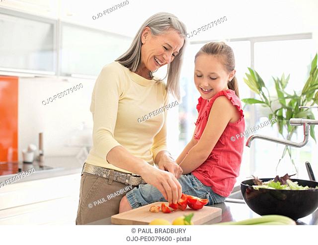 Grandmother and granddaughter preparing food together