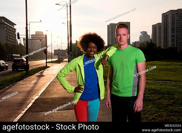 portrait of a young African American beautiful woman and a young man jogging in the city